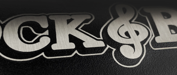 close up etching of black metal growler