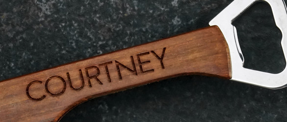 close up of surface etching on wood bottle opener