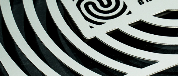 close up of cutouts in stainless steel business card