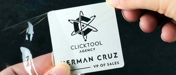 square metal business card wrapped in clear plastic sleeve for protection