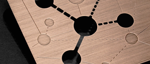 copper finish metal business card showing chemically cut-through and etched areas